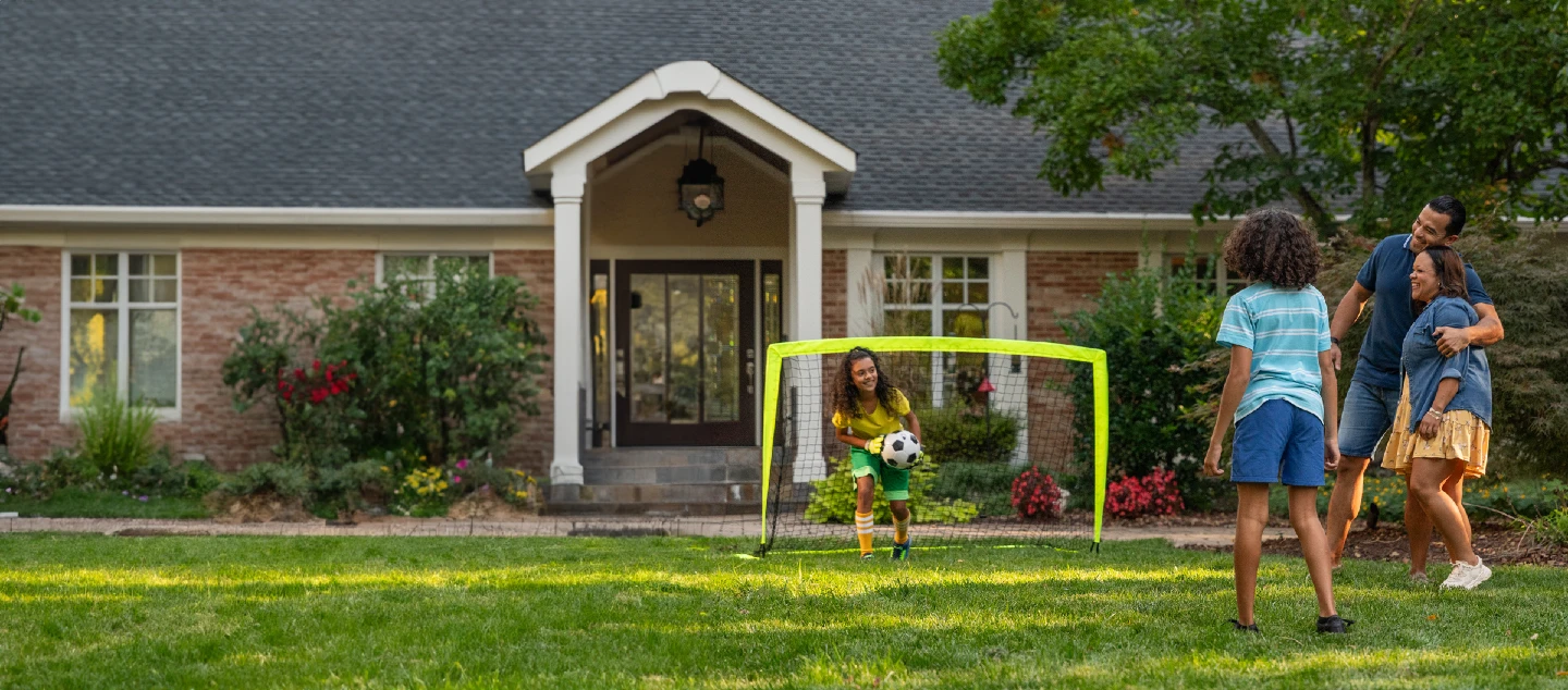 Family playing soccer in the backyard.