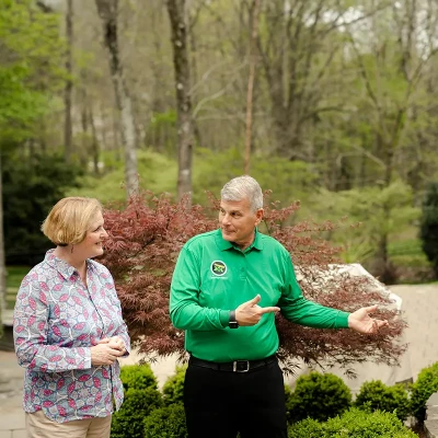 Mosquito Joe technician and customers talk in a yard.