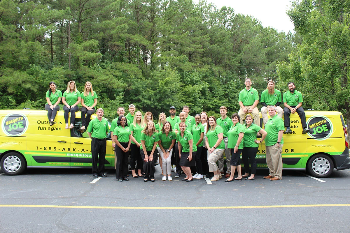 Mosquito Joe team standing in front of two company vans.