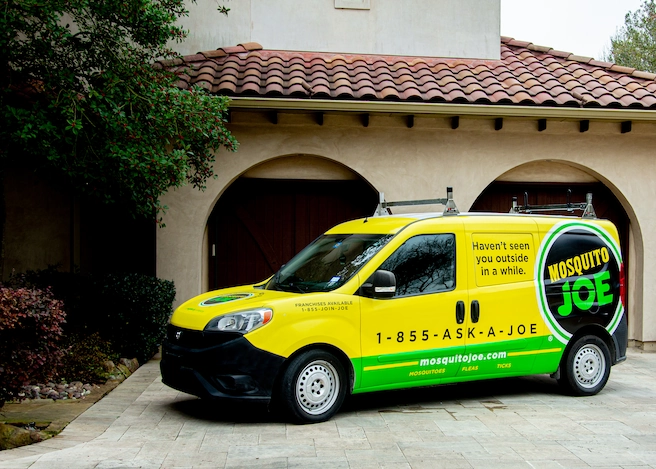 Mosquito Joe van parked in front of house.