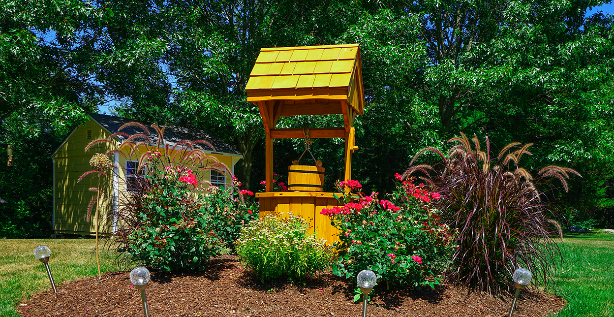 Yellow well with a garden around it.