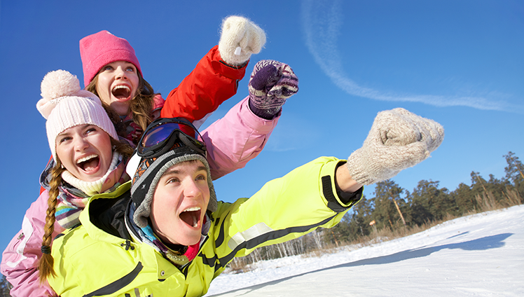 Family laying in snow appearing to fly.