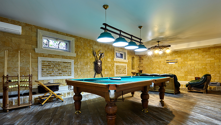 A basement man cave game room with a pool table.