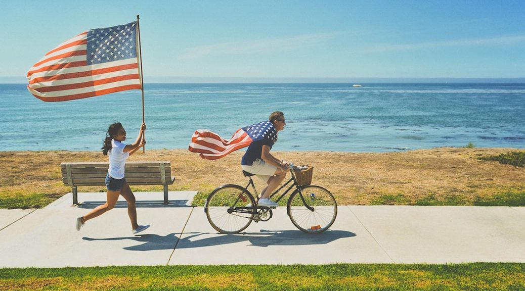 Two individuals proudly displaying an American flag.