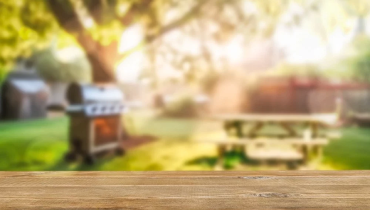 A wooden table top with a blurred garden background, creating a serene outdoor atmosphere.