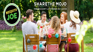 A group of people sitting around a wooden table.