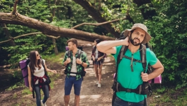 Group of hikers on trail irritated by mosquitos.