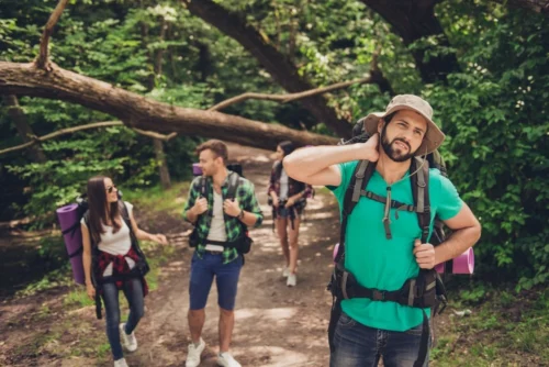 Group of hikers on trail irritated by mosquitos.