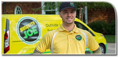 A mosquito joe spray technician standing besides the van.