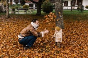 Dad and girl playing in leaves.