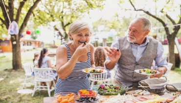 Elderly couple eating outside.