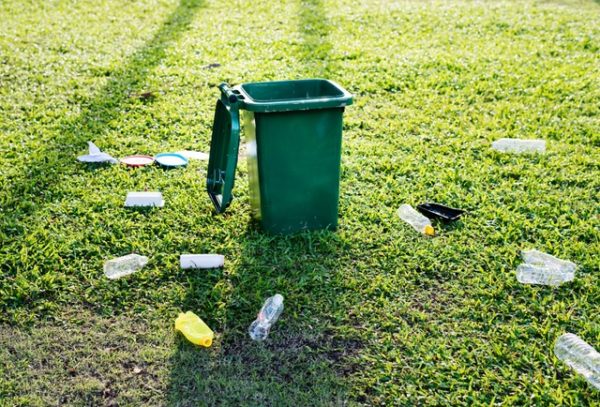 Empty bottles surruonding open trash can.