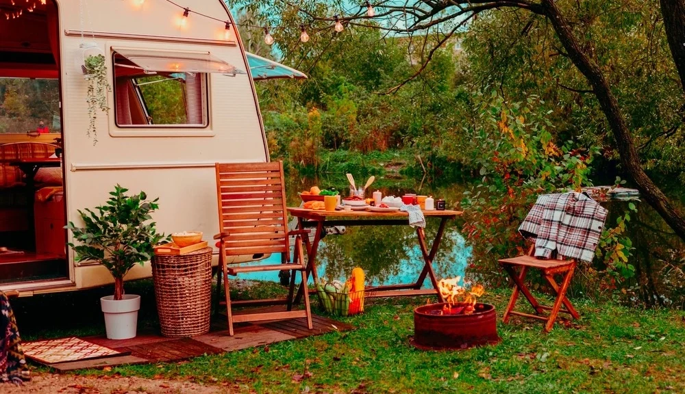 RV with toutside able and chairs set up for dinner.