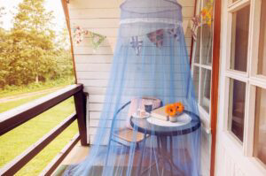 Outdoor table and chair beneath mosquito netting.