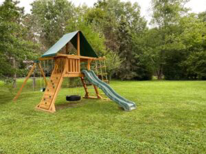 Playset outside with slide and tire swing.