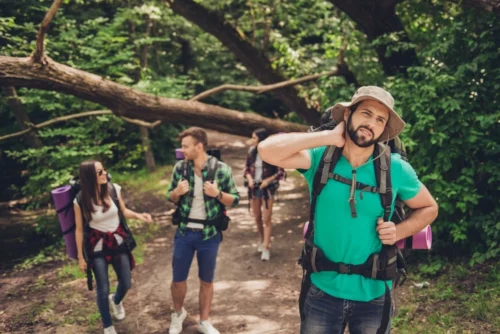 Group of hikers on trail irritated by mosquitos